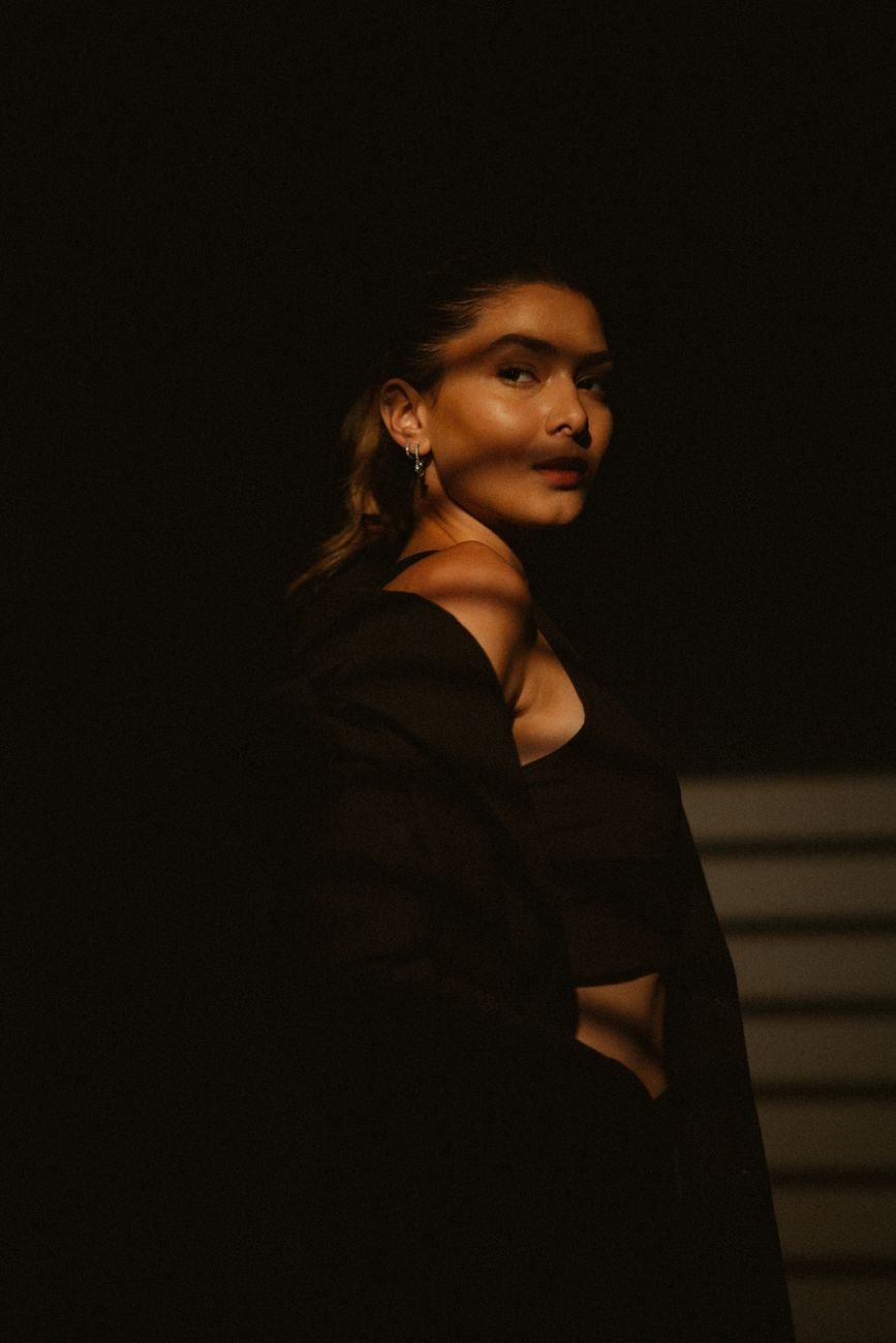 Dramatic portrait of a woman in cinematic moody lighting showcasing fashion.